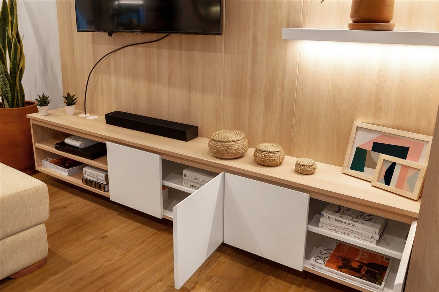 Maßgefertigtes Sideboard aus Holz mit weißen Fronten, Regalböden und dekorativen Accessoires