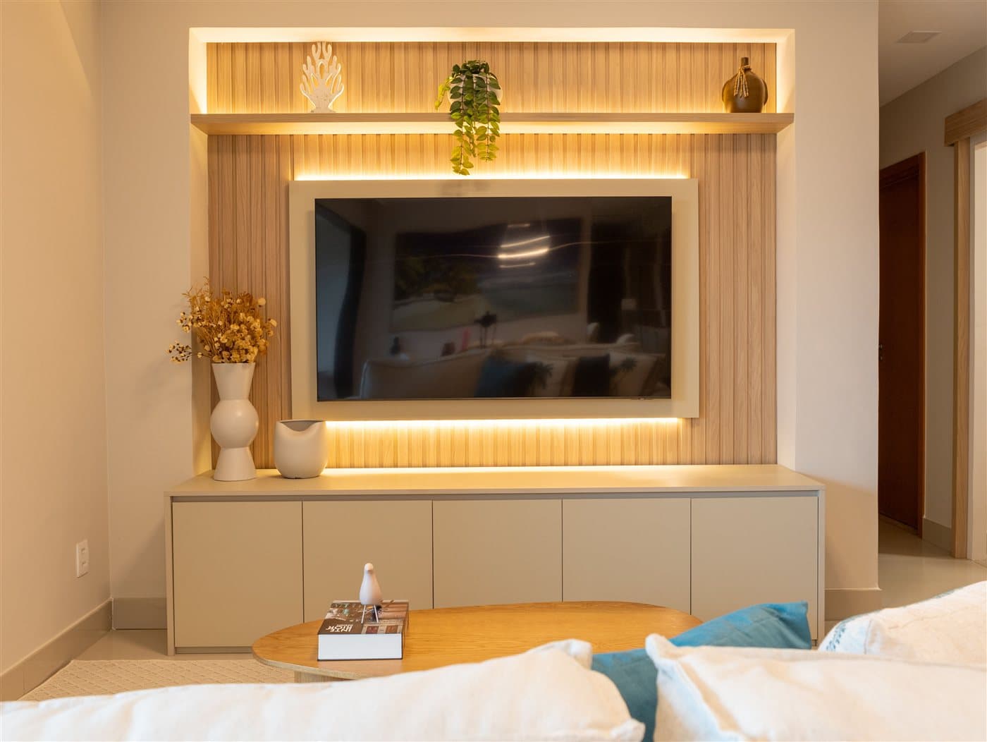 Wohnzimmer mit beleuchteter Holzpaneel-Wand, Sideboard, Vasen und Couchtisch